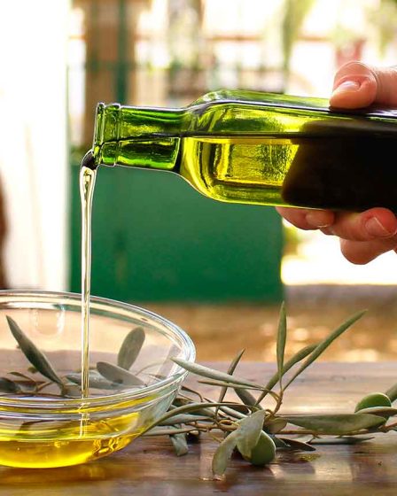 mano sirviendo aceite de oliva en recipiente
