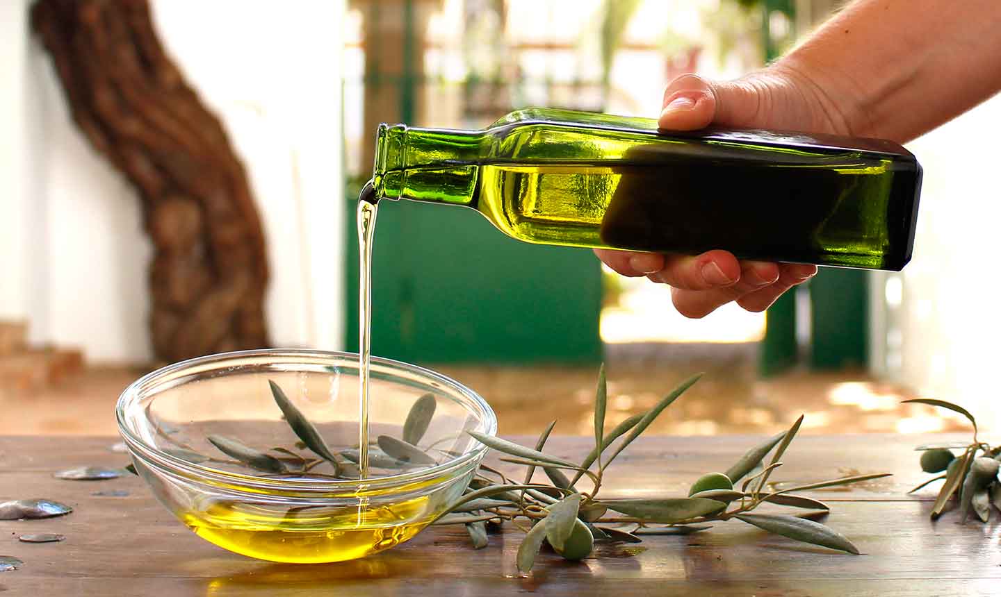 mano sirviendo aceite de oliva en recipiente