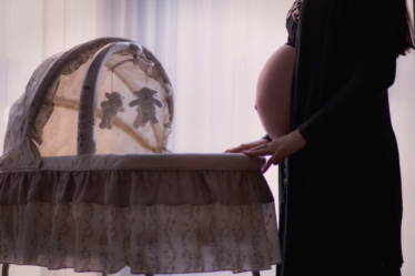 mamá embarazada frente a la cuna
