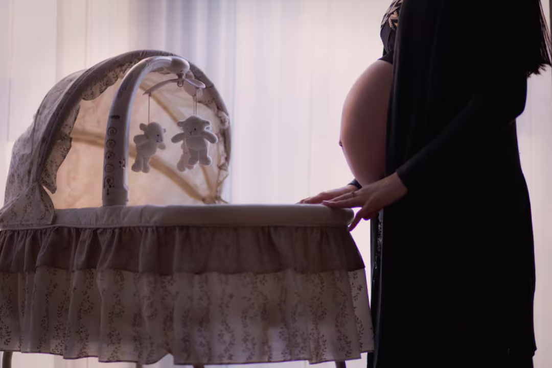 mamá embarazada frente a la cuna