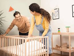 papás preparando cuna para bebé